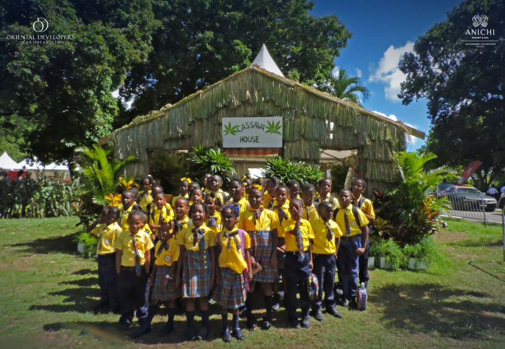 Children gather at the entrance of Ti Vilaj Kweyol’s Cassava House in 2024, where displays showcase the remarkable versatility of this traditional crop.